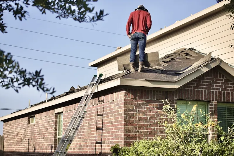 Professional roofer working on a residential roof in West Peabody